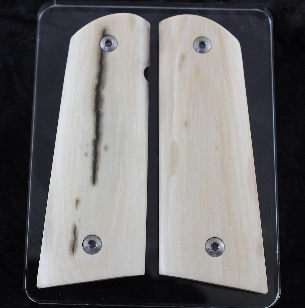 Two wooden gun grips with metal screws on a clear background