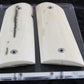 Two wooden gun grips on a clear acrylic stand against a dark background