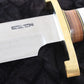 Knife with a wooden handle and brass guard on a black background